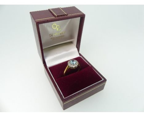A small blue topaz and diamond Cluster Ring, mounted in 18ct yellow and white gold, Size K, approx total weigh 3.3g. 