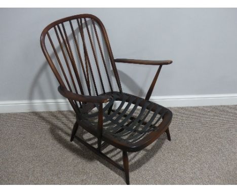 An Ercol dark low Armchair, lacking cushions or covers, with original sticker to back, 27in (68cm) wide x 27in (68cm) deep x 