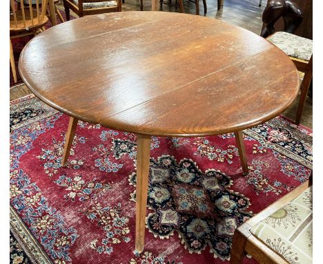 A vintage Ercol circular Table, raised on four circular legs with sticker, 44in (112cm) diameterx28n (71cm) high. 
