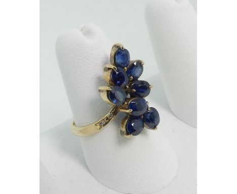 A sapphire cluster Dress Ring,&nbsp;the front claw set with eight oval facetted sapphires, with two diamond points on each sh