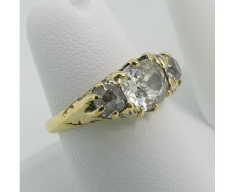 A three stone Diamond Ring,&nbsp;the centre old cut stone c. 1.2ct., with a smaller old cut stone on each side, each c.¼ct, a