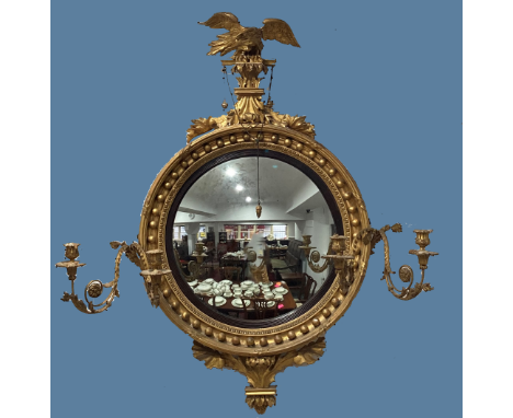 A Regency-style giltwood Girandole Mirror,&nbsp;surmounted with a carved eagle, with circular convex plate, encased in moulde