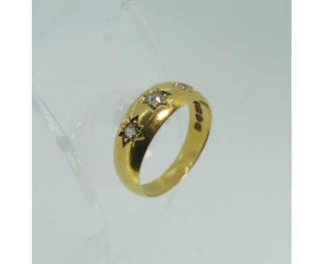 An 18ct yellow gold three stone gypsy set diamond Ring, Size M½, approx total weight 4.8g. 