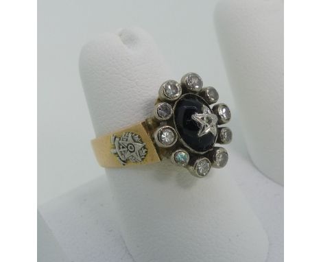 An onyx and diamond Dress Ring, the central cabochon black stone with applied diamond set star top surrounded by ten collet s