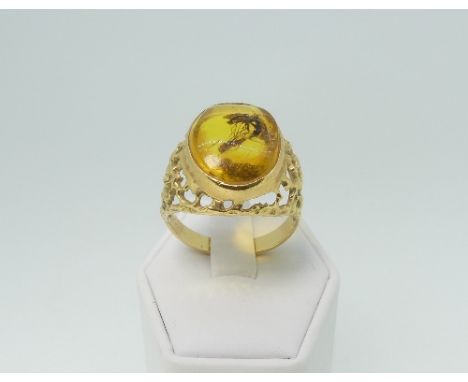 An 18ct yellow gold and amber Ring, the oval amber centre with integral 'insect' pierced tapering shoulders and gold shank, S