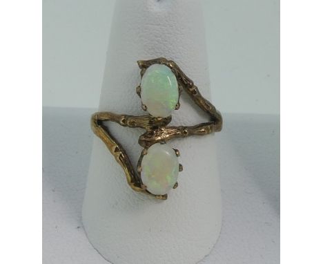 An opal Dress Ring,&nbsp;the two oval opals claw set vertically above each other on a open naturalistic 9ct gold framework mo