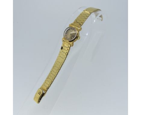 An Omega l8ct gold and diamond lady's Wristwatch, marked "750", the 15mm diameter circular dial with raised button markers an