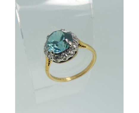 A zircon and diamond Dress Ring, the circular facetted central 'electric' blue stone surrounded by fourteen small diamonds, a