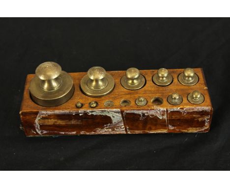 Block of brass weights. Incomplete with three of the lighter weights missing. H.9 x W.22 cm. 