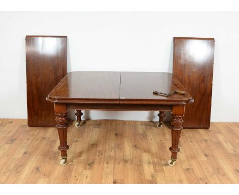 A Victorian mahogany extending dining table, raised on fluted legs and ceramic castors, with two additional leaves and winder