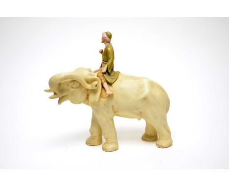 A Royal Dux decorative ceramic figure of an elephant and mahout, the mahout with gilt colouring to his clothes, faint stamp a