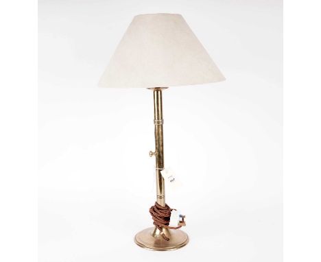 A turned brass table lamp, converted from an extending candlestick, with cream shade, 68cms high.