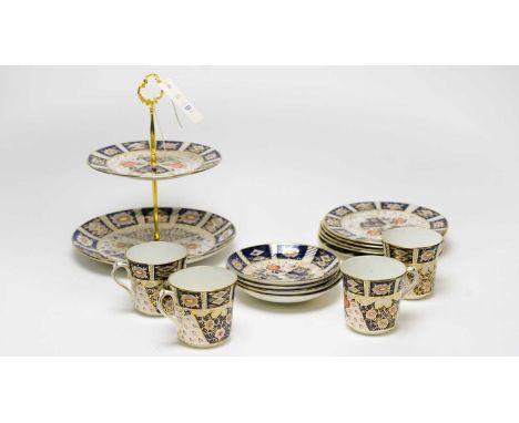 An Imari pattern ceramic tea service, in the style of Royal Crown Derby, comprising: a two-tier cake stand, and four tea trio