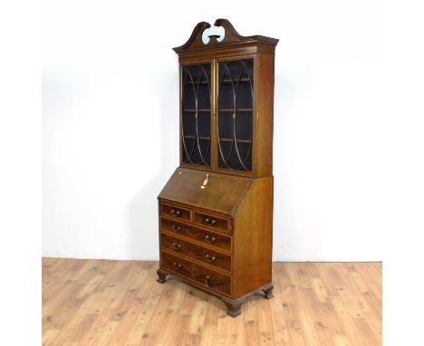An Edwardian mahogany bureau bookcase, with scrolled pediment, astragal glazed doors enclosing shelves, fall front writing ar