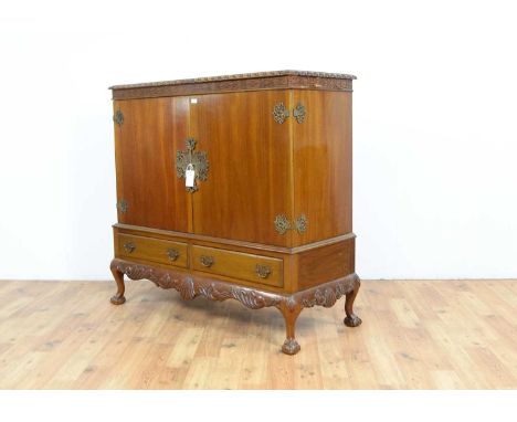 A Chinese Chippendale style hardwood two door cabinet, with blind fretwork to the frieze, pierced ornate hinges and escutcheo