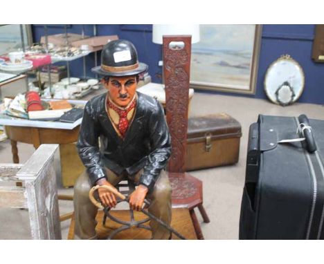 MODERN COMPOSITION FIGURE MODELLED AS CHARLIE CHAPLIN
modelled as seated on a metal chair and holding a walking stick, 63cm h