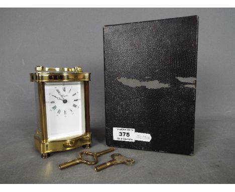 A French 8 day carriage clock in serpentine front, lacquered brass case, white enamel dial signed Angelus, approximately 15 c