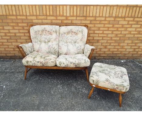 Ercol - A two seat sofa and footstool in Golden Dawn finish. [2]