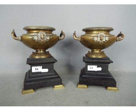 A pair of bronze urns raised on plinths (one plinth A/F), approximately 22 cm (h). [2]