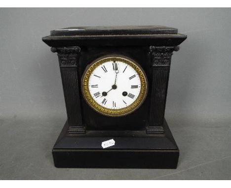 A black marble mantel clock of architectural form, Roman numerals to a white enamel dial, 26 cm (h)
