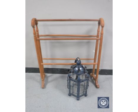 A stripped pine towel rail together with a metal and glass light fitting in the form of a lantern 