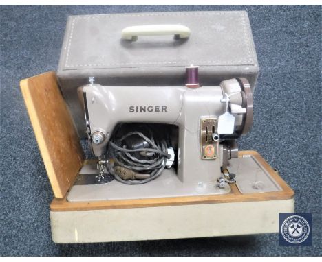 A vintage Singer electric sewing machine in case 