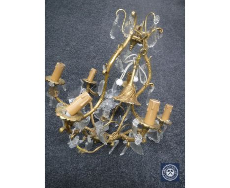 An antique gilt metal five-way light fitting with glass drops 