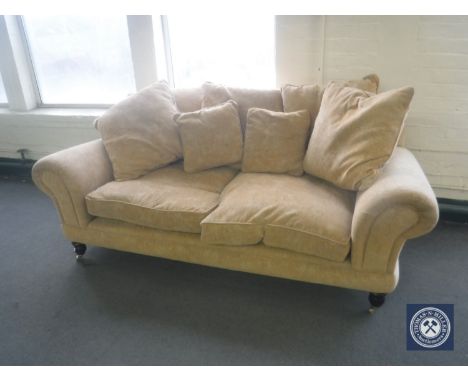 A pair of Barker &amp; Stonehouse two-seater scroll arm settees in gold fabric with scatter cushions 