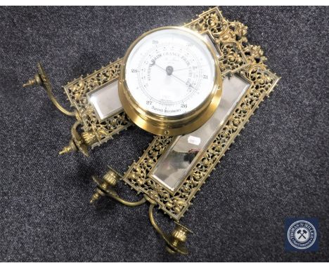 A pair of brass framed narrow wall mirrors with candle sconces together with a ship's style aneroid barometer 