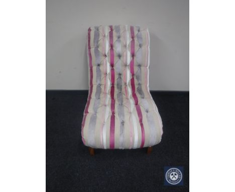 A button back bedroom chair in multi coloured striped fabric. 