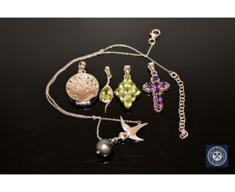 A silver and amethyst crucifix pendant, two silver peridot pendants, a silver locket and a silver and cultured black pearl sw