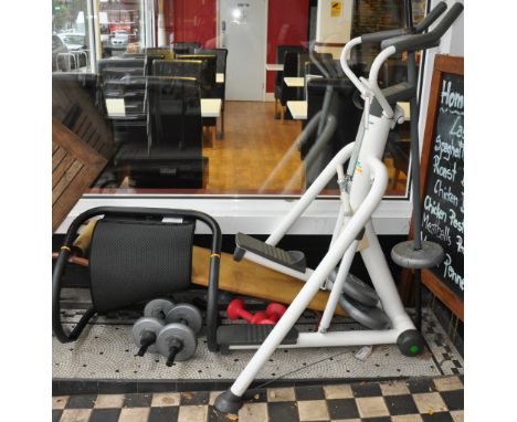 A tunturi eliptical trainer together with an exercise bench and weights