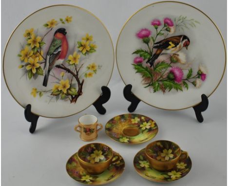 Two early 20th century Royal Worcester porcelain cabinet cups and three saucers painted with spring flowers signed 'Twin', to