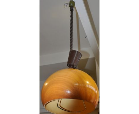 A 1970s simulated wood perspex rise and fall lamp in the style of Guzzini