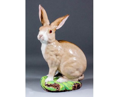 A rare Galle pottery figure of a seated rabbit with glass eyes, on a naturalistically modelled base, with small vase modelled