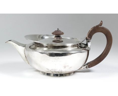 A George III plain silver teapot of squat circular form with fruitwood handle and turned finial, 5ins high, London 1805 (gros