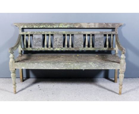 A modern weathered teak garden bench with plain crest rail, the back inset with four metal rectangular plaques cast with elep