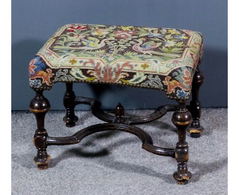 A late 17th Century walnut rectangular stool of "William &amp; Mary" design, the seat upholstered in needlework, on bulbous t