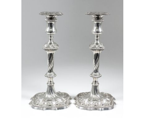 A good pair of early George III cast silver pillar candle sticks, the square sconces with French gadroon mounts, square doubl