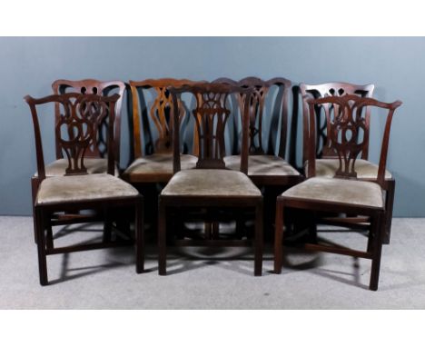 A pair of mahogany dining chairs of "Country Chippendale" design with shaped crest rails, fretted splats amd drop-in seats up