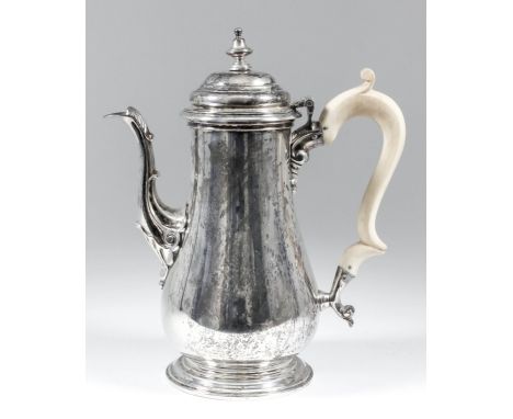 A George V silver baluster shaped coffee pot of "early George III" design, the domed cover with turned finial, cast spout, sh