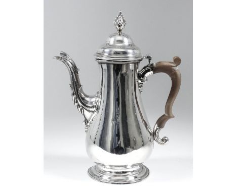 A George III plain silver baluster shaped coffee pot, the domed cover with cast pineapple finial and cast spout with leaf orn