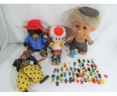 A quantity of soft toys, including Paddington Bear, Toad, vintage clown puppet and a quantity of Lego figures. 