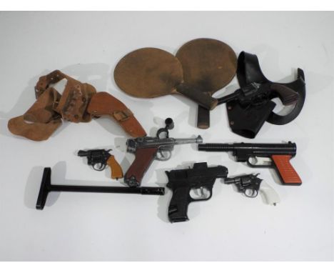 A good mixed lot of vintage toys including four cap guns including Crescent Luger, gun holsters and table tennis bats Est £20