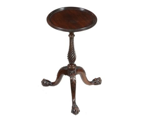 A mahogany wine table in George III style, 20th century, the circular top above twist stem and tripod base, each leg with car