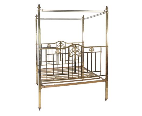A brass four poster bed in Victorian style, 20th century, the ring finials above canopy rails and the four square section pos