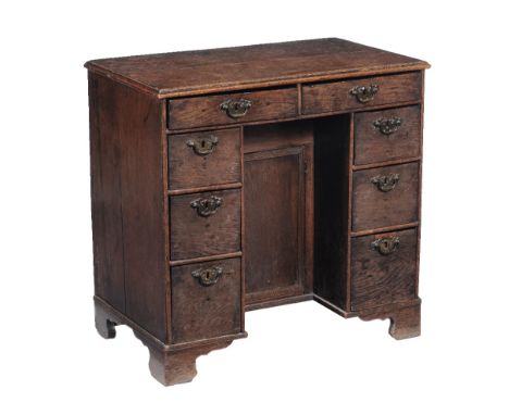 A George III oak kneehole desk, circa 1820, the rectangular top, with moulded edge, two frieze drawers and three short drawer