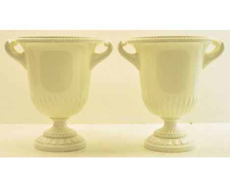 A pair of Royal Worcester white glazed two handled Campana shape Vases on pedestal feet.  9" (23cms) high. 