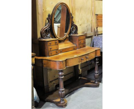 A Victorian mahogany Duchesse Dressing Table with oval swing mirror, six trinket drawers and centre glove drawer, with a smal