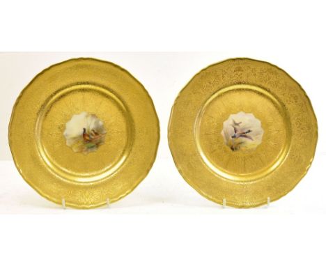 A pair of Royal Worcester Plates each painted with a panel of pheasants and ducks by James Stinton, within a raised and burni